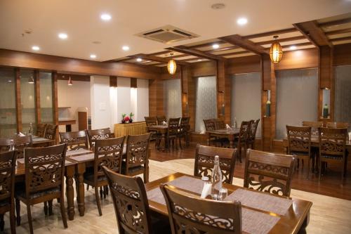 a dining room with wooden tables and chairs at Hotel High Point in Tiruchchirāppalli