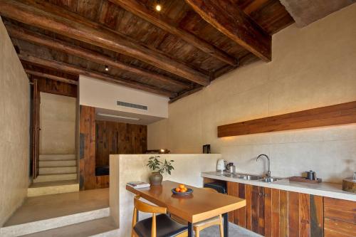 cocina con techos de madera y mesa de madera en Xipo Moganshan Resort Homestay, en Houhong