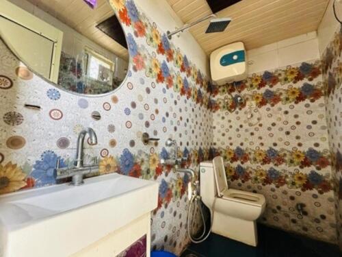 a small bathroom with a sink and a toilet at Aagman Homestay & Rooftop Restaurant in Mussoorie