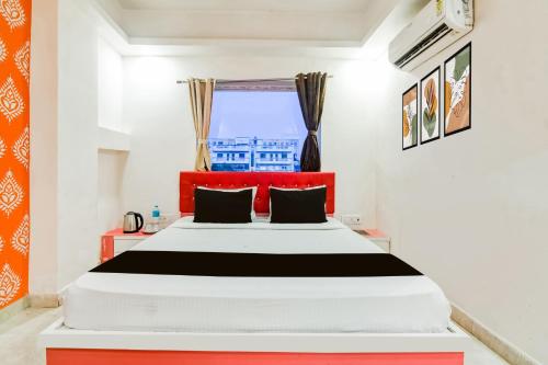 a bedroom with a large bed with a red headboard at Super Collection O City Center New Town Kolkata Formerly Paradise Inn in Salua