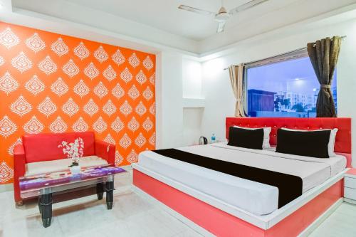 a bedroom with a bed and a red wall at Super Collection O City Center New Town Kolkata Formerly Paradise Inn in Salua