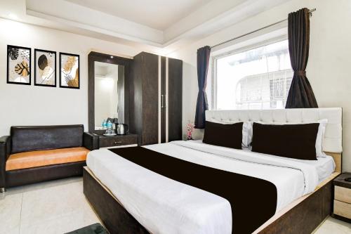 a bedroom with a large bed and a window at Super Collection O City Center New Town Kolkata Formerly Paradise Inn in Salua