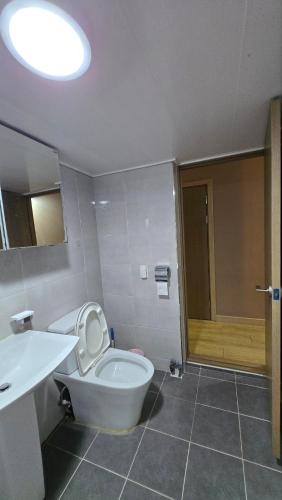 a bathroom with a toilet and a sink and a mirror at A Bridge House 1C-1 in Jung-gu