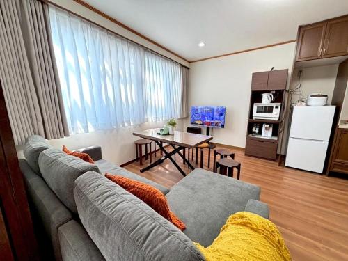 a living room with a gray couch and a table at New! Stay in Kamata West Exit Gourmet Street! in Tokyo