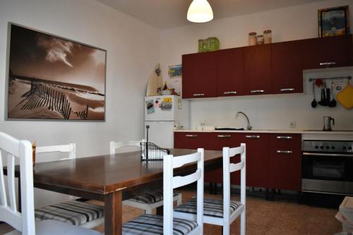 eine Küche mit einem Holztisch und weißen Stühlen in der Unterkunft Famara home Stay 1 in Famara