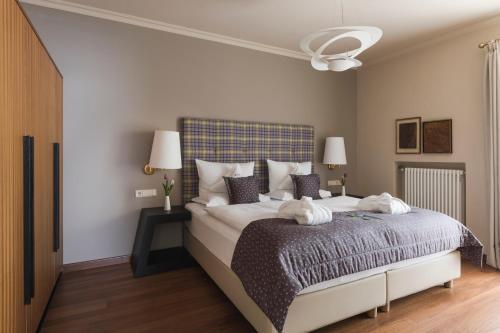 a bedroom with a large bed with a blue headboard at Hotel Mignon Meran Park & Spa in Merano