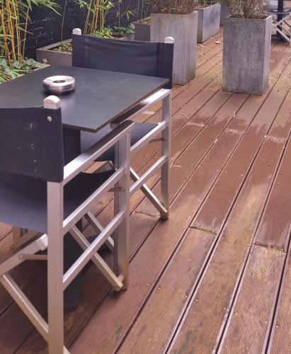 a table and a chair on a deck at YOOMA Urban Lodge in Brussels