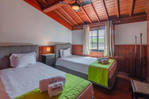 a bedroom with two beds and a window at Refúgio do Sol - Azorean Butler in Mosteiros