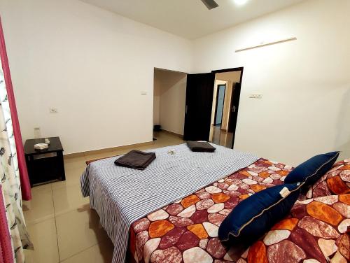 a bedroom with a bed with blue pillows on it at Happy Buddha Varkala in Varkala