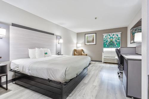 a hotel room with a large bed and a desk at Quality Inn Edmund Pettus Bridge area in Selma