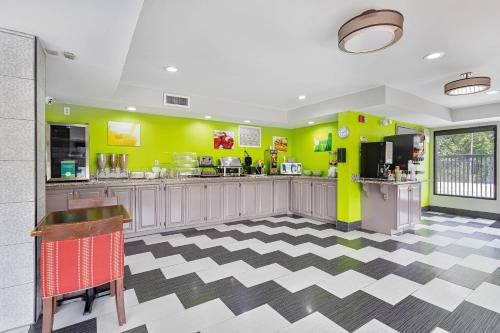 a restaurant with yellow walls and a checkered floor at Quality Inn Edmund Pettus Bridge area in Selma