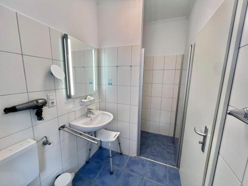a white bathroom with a sink and a shower at Landhaus Fillerberg in Wildeshausen