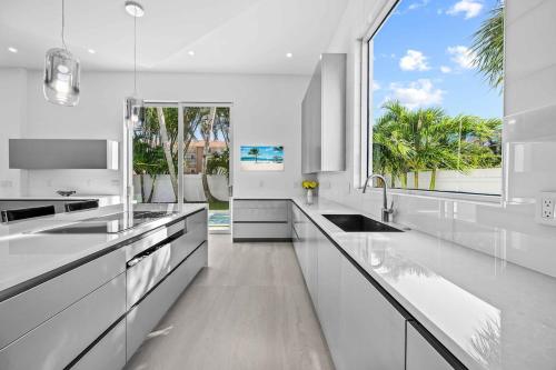 a kitchen with white counters and a large window at Luxury New Modern Beach Mansion in BEST Location! in Jupiter