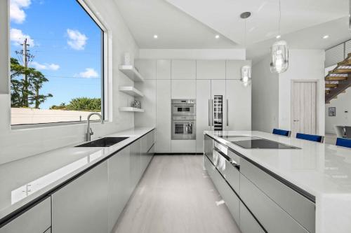 a kitchen with white counters and a large window at Luxury New Modern Beach Mansion in BEST Location! in Jupiter