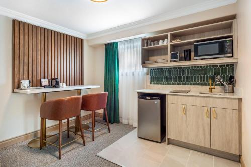 a hotel room with a kitchen with a bar and chairs at Velora Hinton, an Ascend Collection Hotel in Hinton