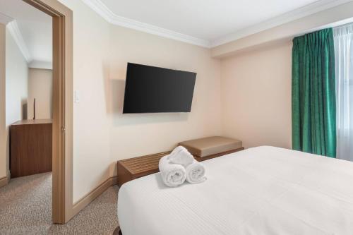 a hotel room with a bed and a flat screen tv at Velora Hinton, an Ascend Collection Hotel in Hinton