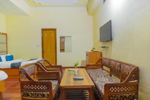 a living room with a couch and a table and a bed at Hotel Abhi international in Pathānkot