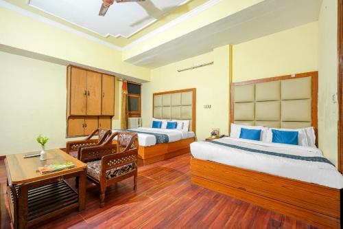 a hotel room with two beds and a table at Hotel Abhi international in Pathānkot