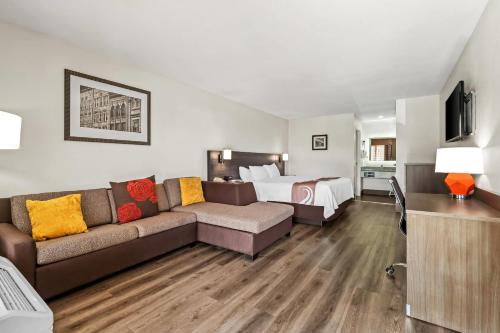 a living room with a couch and a bed at Quality Inn & Suites near Robins Air Force Base in Warner Robins