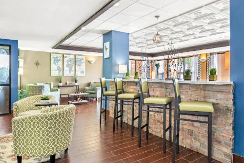 a lobby with a bar with stools at Quality Inn & Suites near Robins Air Force Base in Warner Robins