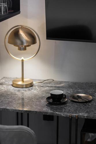 a table with a lamp and a cup on it at IL CONFORMISTA Casa Storica in Thessaloniki