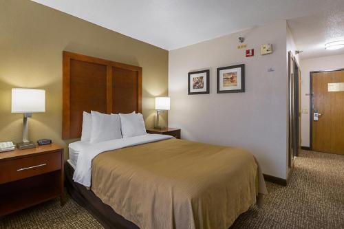 una camera d'albergo con un letto, due lampade e una porta di Quality Inn Waverly a Waverly