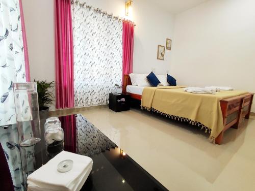 a hotel room with a bed and a window at Happy Buddha Varkala in Varkala