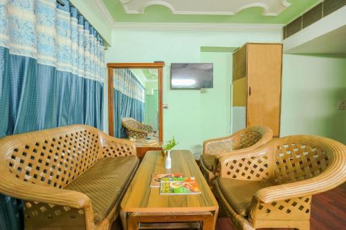 a living room with two wicker chairs and a table at Hotel Abhi international in Pathānkot