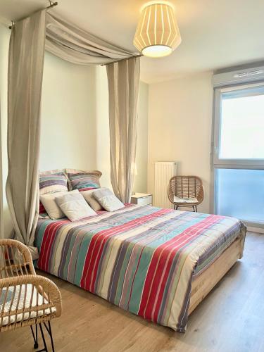 a bedroom with a large bed with a colorful blanket at Urban Nest - Paris - CDG - Parking & Confort in Pavillons-sous-Bois
