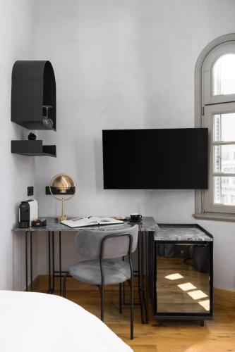a bedroom with a desk with a television on a wall at IL CONFORMISTA Casa Storica in Thessaloniki