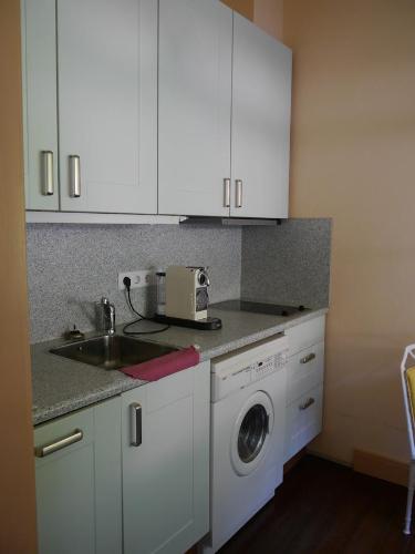 a kitchen with a sink and a washing machine at Haus Honigstal Landhaus Café in Wuppertal