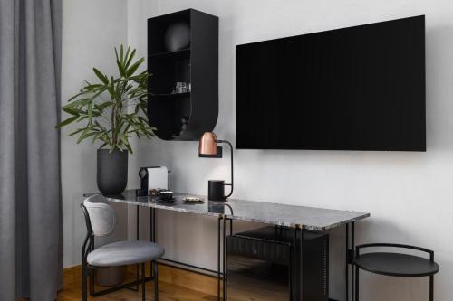 a desk with a potted plant and a television on a wall at IL CONFORMISTA Casa Storica in Thessaloniki