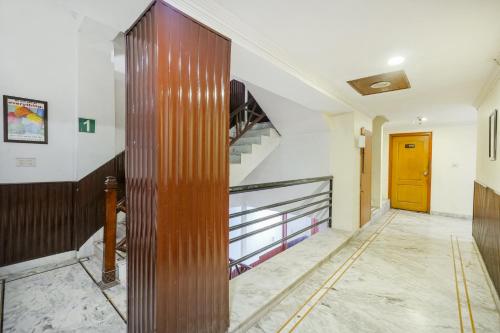 a hallway with a staircase and a yellow door at Hotel Abhi international in Pathānkot