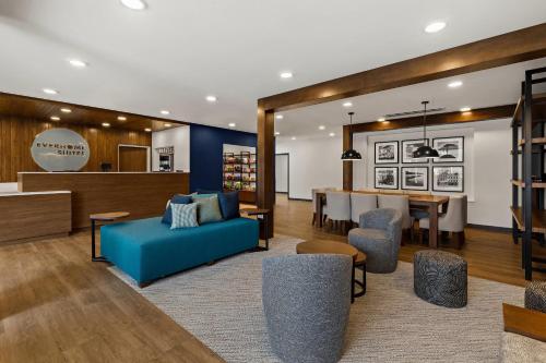 a lobby with a blue couch and a dining room at Everhome Suites Somerset - South Brunswick in Somerset