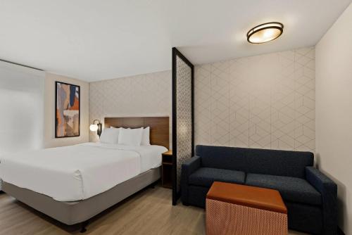 a hotel room with a bed and a couch at Everhome Suites Somerset - South Brunswick in Somerset