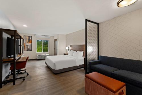 a hotel room with a bed and a couch at Everhome Suites Somerset - South Brunswick in Somerset