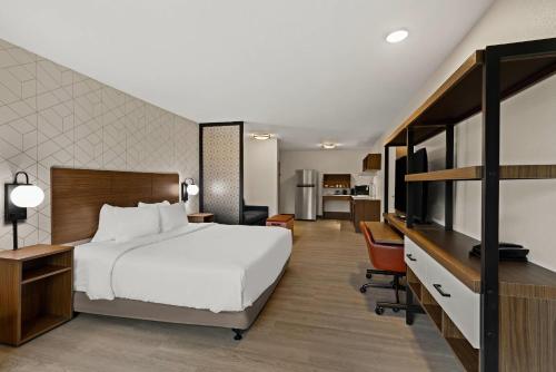 a hotel room with a large bed and a desk at Everhome Suites Portsmouth - Newington in Newington