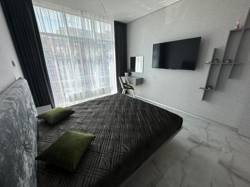 a hotel room with a bed and a large window at Елегія парк in Odesa