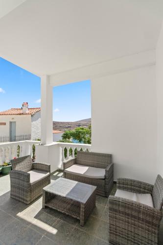 a patio with wicker chairs and a table with a view at Chora Sea Nest, 2-BDR Flat in Andros Town in Andros