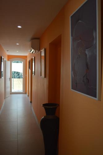 a hallway with orange walls and a vase on the wall at Villa Rasoa in Cap d'Agde