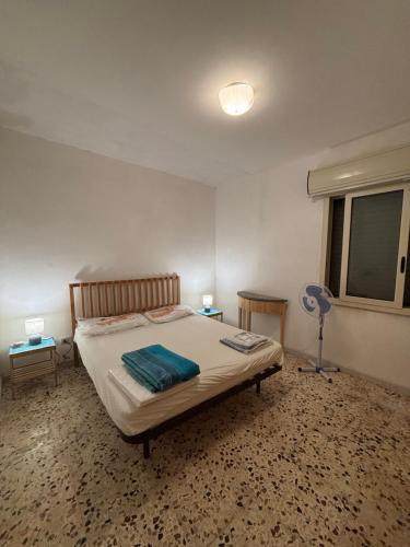 a bedroom with a bed and a fan and a window at Aloha Sicily in Granelli