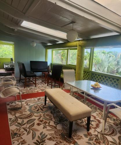 a living room with a table and chairs and a piano at Fully renovated 4 bd with 2 master suits, 3 bth home in centralized location in Keaau