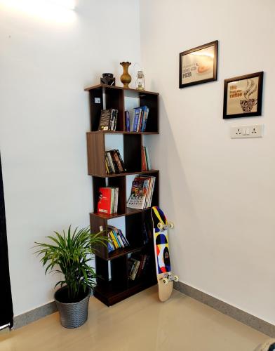 a book shelf with books and a skateboard in a room at Happy Buddha Varkala in Varkala