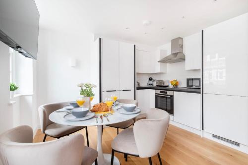 a kitchen and dining room with a table and chairs at BnBNova - Soho & Fitzrovia with Balcony in London