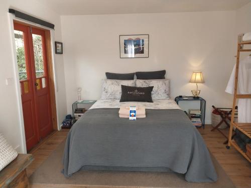 1 dormitorio con 1 cama grande con manta gris en Studio Solaris, en Daylesford