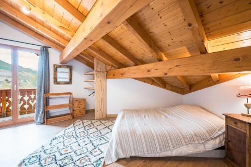 a bedroom with a large bed and wooden ceilings at Chalet Marmotte in Saint-Martin-de-Belleville