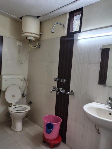 a bathroom with a toilet and a sink at Hotel Sandhyana Inn in Dharamshala