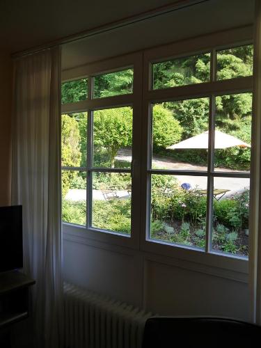 a window in a room with a view of a yard at Haus Honigstal Landhaus Café in Wuppertal