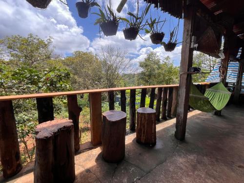a porch with a hammock and tree stumps at Bee Bee's Chalets home stay and trekking in Banlung