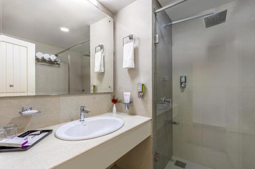 a bathroom with a sink and a shower at Sterling Darshan Guruvayur in Guruvāyūr